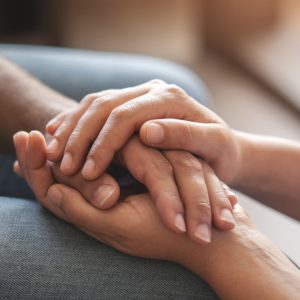 Closeup shot of two unrecognizable people holding hands in comfort