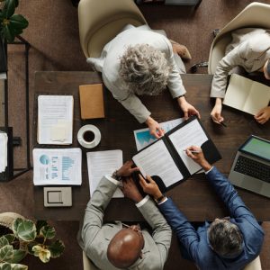 Multiethnic Middle Aged Executives Discussing Documents during Office Brainstorming
